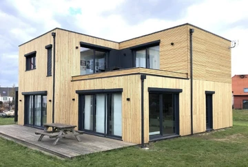 Maison moderne à deux niveaux avec bardage bois vertical, située dans un quartier résidentiel