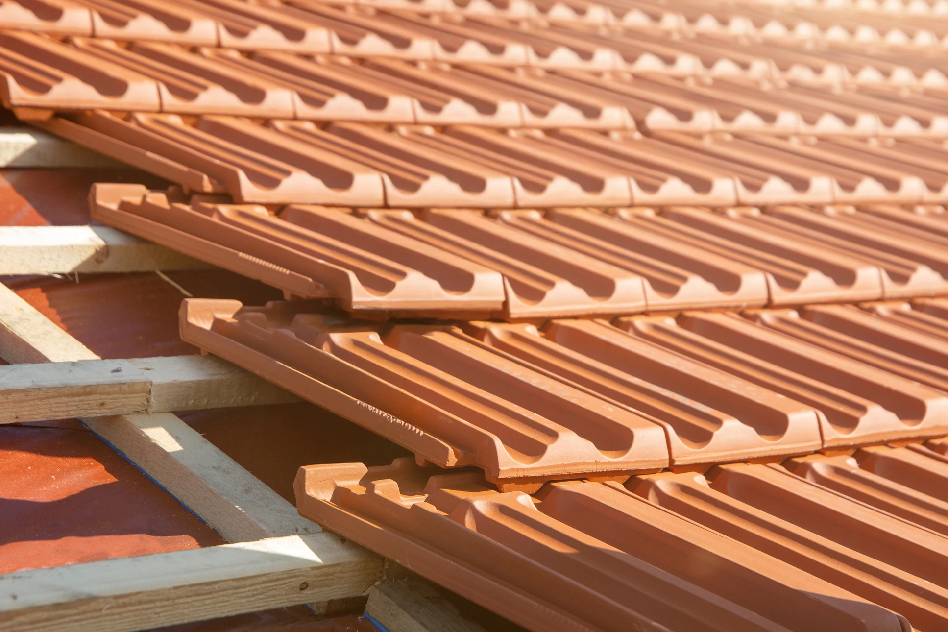 Ext&eacute;rieur, vue en contre-plong&eacute;e d'une toiture en construction sous ciel bleu azur