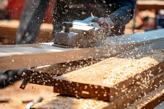 Atelier de menuiserie avec artisan travaillant sur &eacute;tabli en bois massif