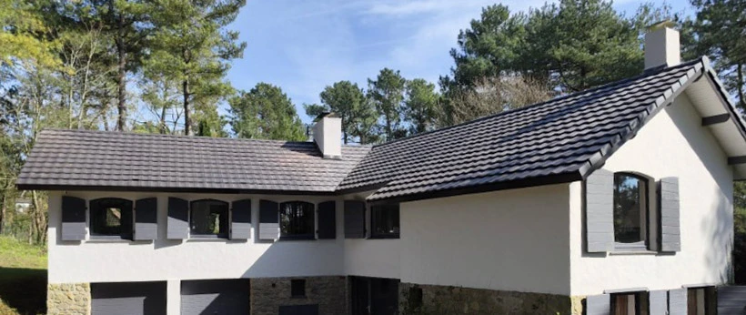 Maison moderne à deux niveaux avec bardage bois vertical, située dans un quartier résidentiel