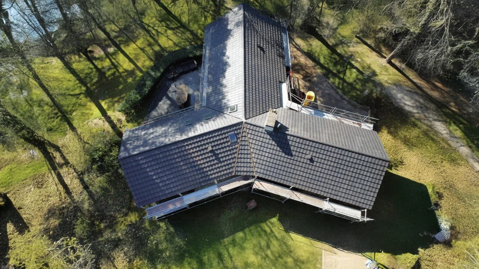 Toiture résidentielle moderne avec bardeaux d'asphalte gris, lucarnes à pignon et fenêtres blanches