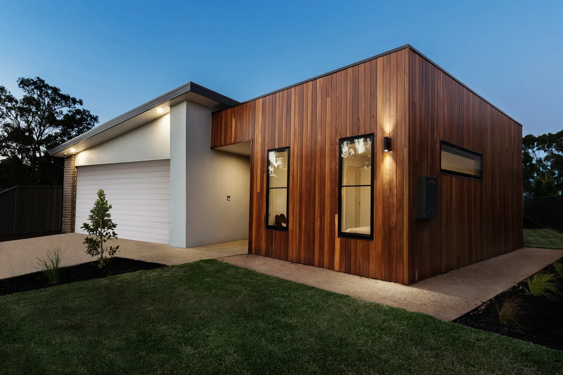 Maison contemporaine à ossature bois avec bardage en lames horizontales, située dans un environnement paysager verdoyant